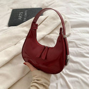 Schultertasche in Halbmondform mit verstellbarem Gurt und Reißverschlusstaschen