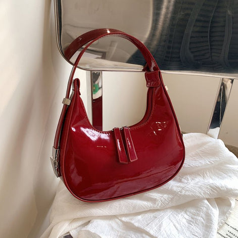 Schultertasche in Halbmondform mit verstellbarem Gurt und Reißverschlusstaschen